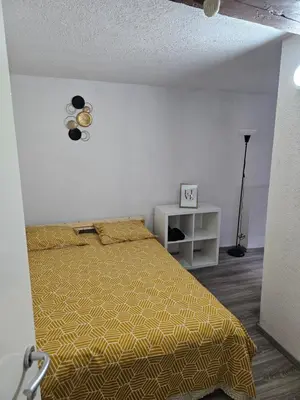 a bedroom with a bed with a yellow bedspread at Logment Outremeuse 1D in Liège