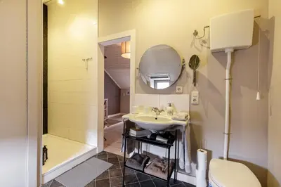 a bathroom with a sink and a toilet and a mirror at Bibi Tongeren in Tongeren
