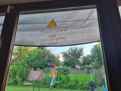 a window view of a garden with a sign on it at Gee is Sharing her home in Liège