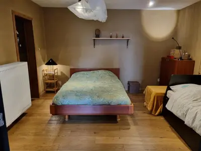 a bedroom with a bed and a table and a bed sqor at Gee is Sharing her home in Liège