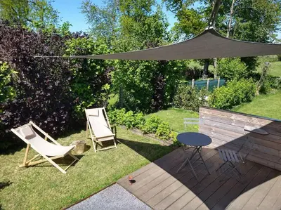 two chairs and a table and an umbrella in a yard at Côté jardin in Dison