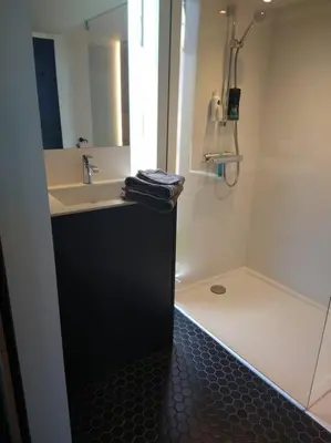a bathroom with a sink and a shower at Côté jardin in Dison