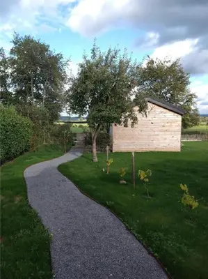 a gravel path leading to a building in a yard at Côté jardin in Dison