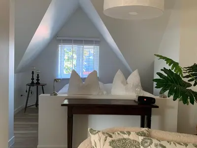 a bedroom with a bed with white pillows and a window at Zolder appartement Le Grenier in Dilsen-Stokkem