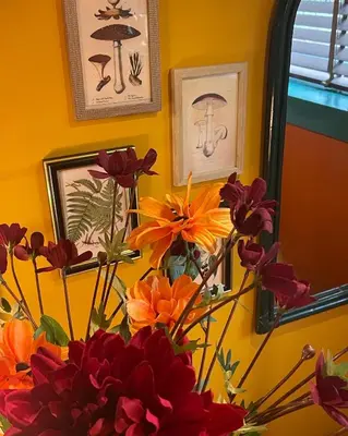 a vase filled with flowers in a room with pictures at Boshuisje Pinus Sonnevijver Residences in Lanaken