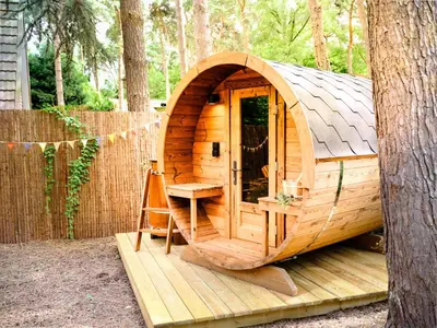 a wooden cabin with a bench and a tree at Boshuisje Pinus Sonnevijver Residences in Lanaken