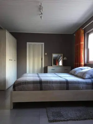 a bedroom with a large bed and a mirror at Le calme de la prairie de liège in Liège