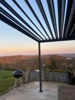 a barbecue grill on a patio with a view at Le calme de la prairie de liège in Liège