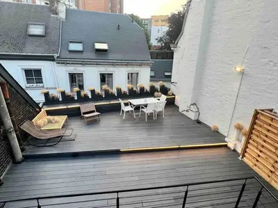 a wooden deck with chairs and a table on a building at Maison avec 4 suites & Rooftop en plein centre ville - Place Saint Paul in Liège