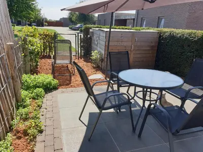 a table and chairs and an umbrella on a patio at Het Zonnetje -Vakantiewoning en Bed and Breakfast in Dilsen-Stokkem
