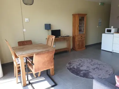 a dining room with a table and chairs and a refrigerator at Het Zonnetje -Vakantiewoning en Bed and Breakfast in Dilsen-Stokkem