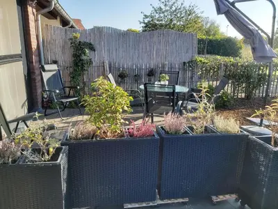 a garden with a table and chairs and a fence at Het Zonnetje -Vakantiewoning en Bed and Breakfast in Dilsen-Stokkem