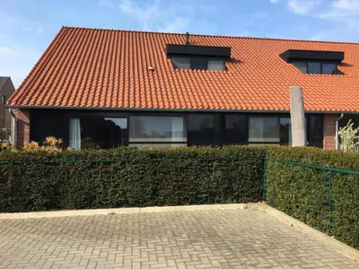 a house with an orange roof and a fence at Het Zonnetje -Vakantiewoning en Bed and Breakfast in Dilsen-Stokkem