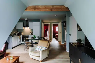 a kitchen and living room with a couch and a table at L’écrin vintage - Hors Château & Marches de Bueren in Liège