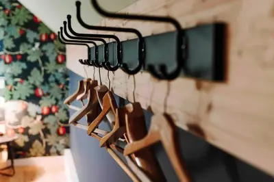 a row of wooden hangers on a wall with a christmas tree at L’écrin vintage - Hors Château & Marches de Bueren in Liège