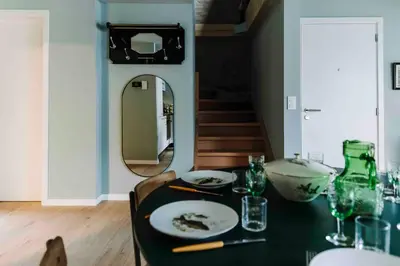 a dining room with a table with a mirror at L’écrin vintage - Hors Château & Marches de Bueren in Liège