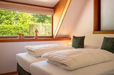 two beds in a room with a window at Boshuisje Rekem - Flora in Lanaken