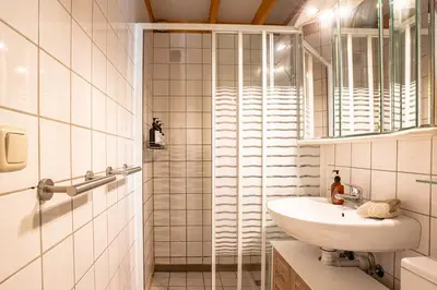 a white bathroom with a sink and a shower at Boshuisje Rekem - Flora in Lanaken