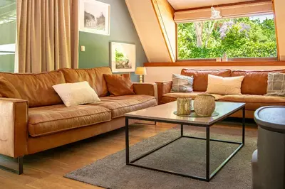 a living room with a couch and a table at Boshuisje Rekem - Flora in Lanaken