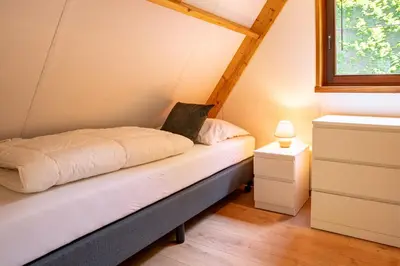 a bed in a room with a window at Boshuisje Rekem - Flora in Lanaken