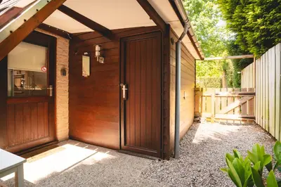 a wooden entrance to a house with a wooden door at Boshuisje Rekem - Flora in Lanaken