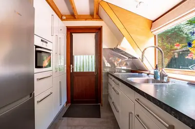 a kitchen with a sink and a door at Boshuisje Rekem - Flora in Lanaken