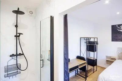 a bedroom with a shower and a bed and a desk at Li Mohone in Donceel