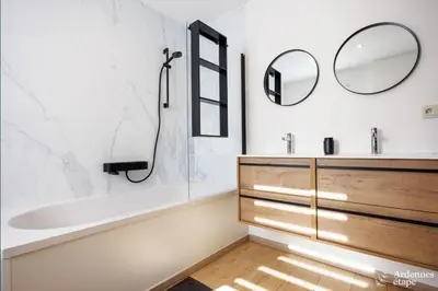 a bathroom with a tub and a sink and a mirror at Li Mohone in Donceel