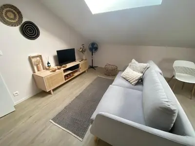 a living room with a white couch and a television at Au saut du Train in Remicourt