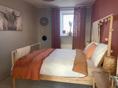 a bedroom with a bed with a wooden headboard at Au saut du Train in Remicourt