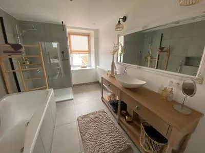a bathroom with a sink and a tub and a mirror at Au saut du Train in Remicourt
