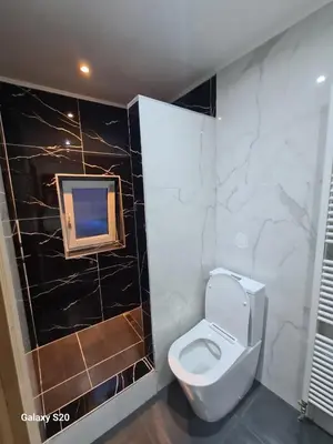 a bathroom with a toilet and a tv on the wall at Liege in Seraing