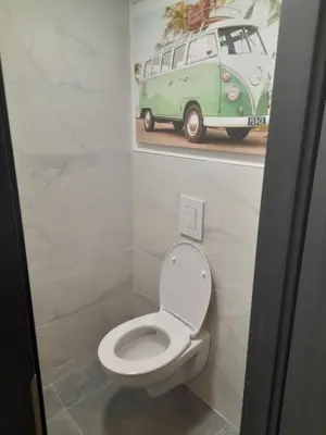 a bathroom with a toilet and a picture of a van at Chez Francis in Verviers