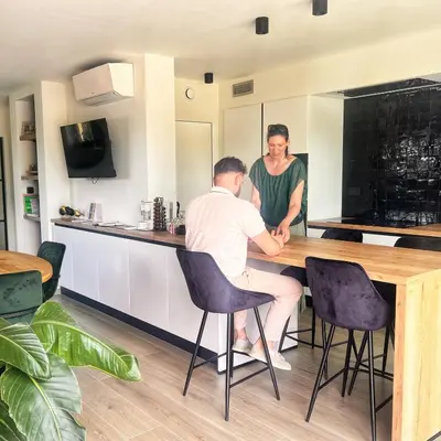 a man and a woman sitting at a table in a kitchen at Inova - Comfort Room with Private Bathroom and Shared Facilities in Hasselt