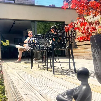 a person sitting at a table and chairs on a deck at Inova - Comfort Room with Private Bathroom and Shared Facilities in Hasselt