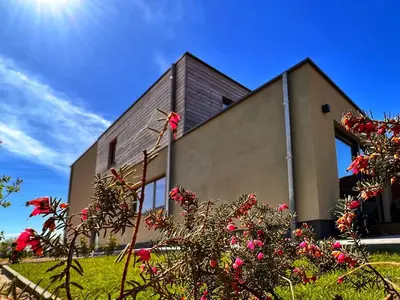 a house on a hill with flowers in the foreground at Inova - Comfort Room with Private Bathroom and Shared Facilities in Hasselt