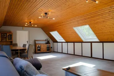 a living room with a couch and a wooden ceiling at Domaine des Arches in Soumagne