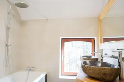 a bathroom with a bowl sink and a tub at Domaine des Arches in Soumagne