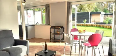 a living room with a table and chairs at Zonnige vrijstaande bungalow in prachtige omgeving! in Rekem