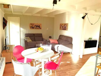 a living room with a white table and pink chairs at Zonnige vrijstaande bungalow in prachtige omgeving! in Rekem