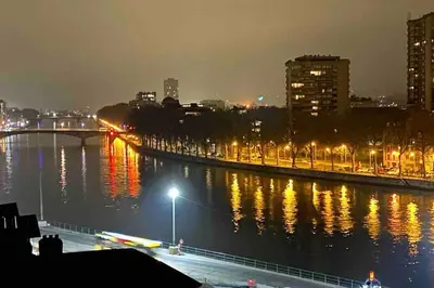 a city at night with lights on the water at Le Neuvice - Place du marché, Quais, Bueren in Liège