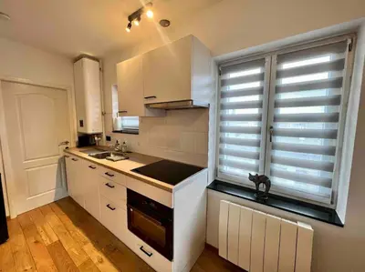 a kitchen with white cabinets and a sink and a window at Le Neuvice - Place du marché, Quais, Bueren in Liège