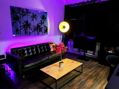 a living room with a black couch and a table at Chambre dans une maison d'hote in Liège
