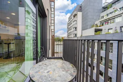 a balcony with a table and some buildings at L'appart Léon, avec parking gratuit in Liège