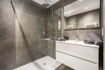 a bathroom with a shower and a sink and a mirror at L'appart Léon, avec parking gratuit in Liège