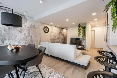 a living room with a white couch and a table at L'appart Léon, avec parking gratuit in Liège