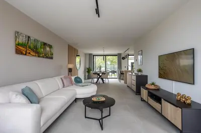 a living room with a white couch and a flat screen tv at NIEUW - De Grenspaal WEST 6P 5 min Maastricht - Sauna - Laadpaal in Riemst