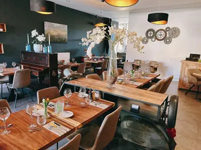 a restaurant with wooden tables and chairs and flowers at Hoeve de Sterappel in Tongeren