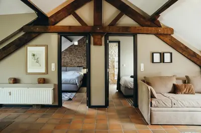 a living room with a couch and a bedroom at La Terrasse du Pré by WelcHome in Verviers