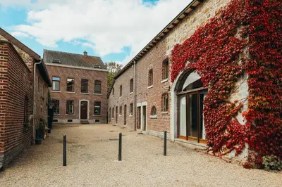 a bunch of red flowers on the side of a building at La Terrasse du Pré by WelcHome in Verviers
